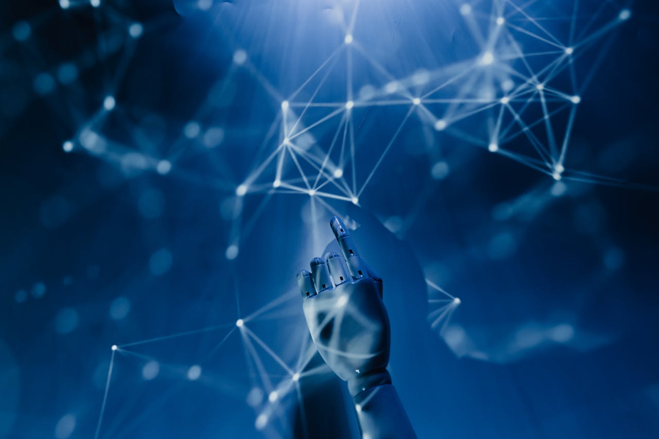 creative-01 A robotic hand reaching into a digital network on a blue background, symbolizing AI technology.
